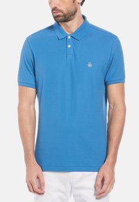 Blauwe polo shirt van katoen, met een klassieke kraag, korte mouwen en een klein pinguïnlogo op de borst. Glad textuur.