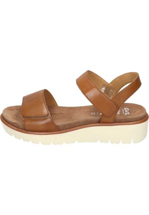 Brown leather sandal with two wide straps, soft suede insole, and a white platform sole. Features a rounded toe and textured exterior.
