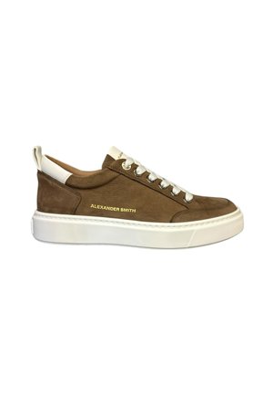 Baskets en suède marron avec des accents en cuir blanc, lacets plats et une semelle épaisse en caoutchouc blanc. Présente un logo imprimé en doré sur le côté.
