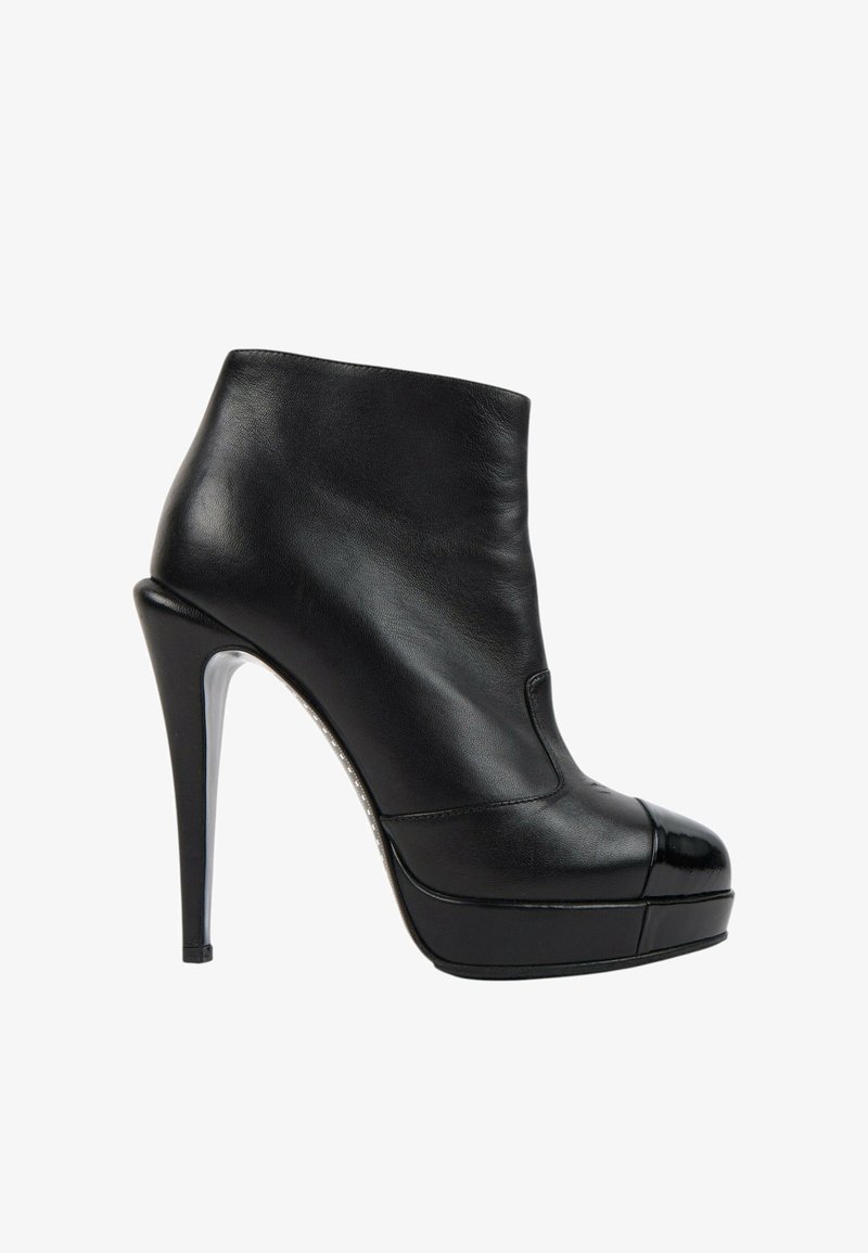 Bottine noire en cuir à talon haut avec embout brillant et semelle plateforme, vue de profil extérieur sur fond blanc.