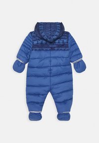 Niebieski ocieplany kombinezon niemowlęcy z przymocowanymi rękawiczkami, osłonami na stopy i kapturem, ozdobiony ciemnoniebieskim wzorem leśnym oraz logo Timberland.