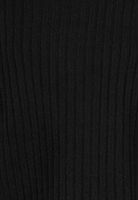 Schwarzer gerippter Strickstoff mit vertikalen Linien und leicht flauschigen Fasern.