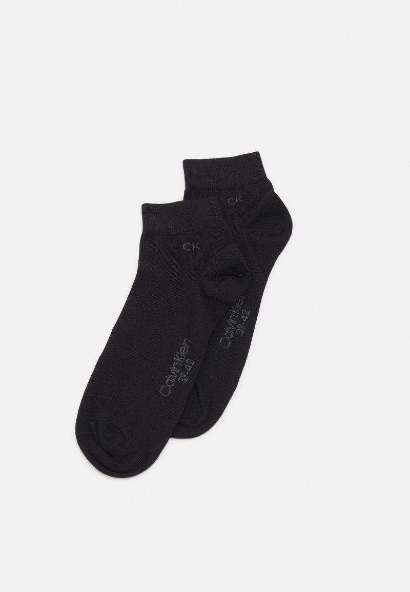Calzini alla caviglia in cotone nero con una texture liscia. Caratteristiche includono punta e tallone rinforzati, e "Calvin Klein 33-42" stampato in grigio.