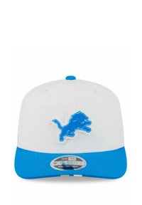 Casquette snapback blanche et bleue avec un logo de lion bleu à l'avant et une visière bleue avec un autocollant New Era 9Seventy.