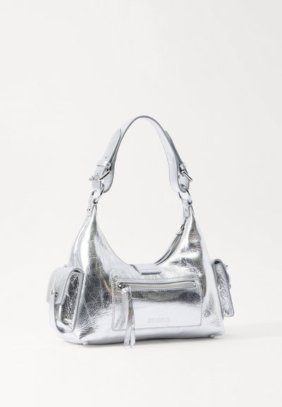 Metallisch zilveren handtas met een gebogen ontwerp, met een cilindrisch lichaam, een verstelbare band en een ritsvak. Gladde, glanzende textuur.