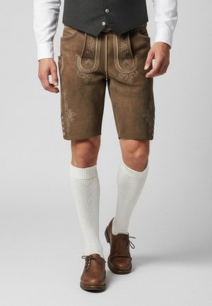Lederhosen de cuero marrón con costuras decorativas, bolsillos laterales y botones, acompañados de calcetas blancas hasta la rodilla y zapatos marrones.
