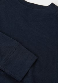 Laivastonsininen pitkähiha paita, tehty pehmeästä kankaasta, jossa on pyöreä kaula-aukko ja taitettu kalvosin. Kangas on sileää ja siinä on hienovarainen kiilto.