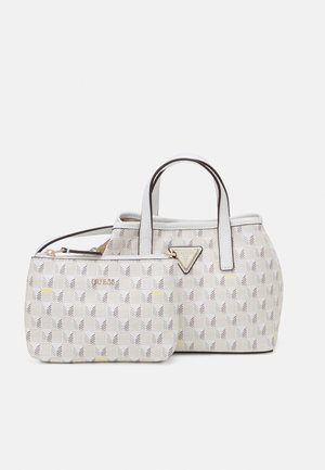 Deux sacs blancs Guess avec des motifs géométriques ; un sac à main avec des poignées supérieures et une petite pochette zippée devant.