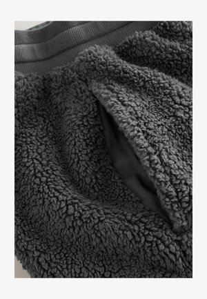 Gray fleece fabric with a textured, plush surface and ribbed waistband. Features an open pocket on one side.