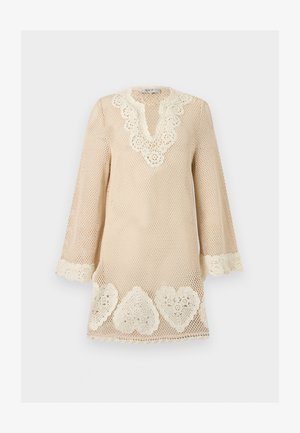 Béžové háčkované šaty s dlouhými rukávy, vroubkovaným výstřihem ve tvaru V a bílými krajkovými vzory srdcí podél lemu a manžet.