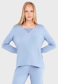 Haut à manches longues bleu clair avec un col en V et un insert en dentelle. Fait d'un matériau doux, il offre une coupe décontractée et un design sans coutures.