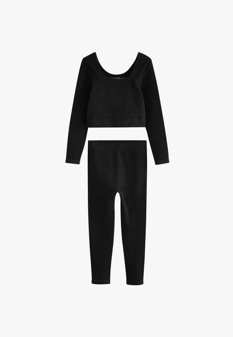 Black ribbed crop top with long sleeves and matching high-waisted leggings. Features a scoop neck and textured fabric throughout.