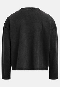 Sweatshirt noir, coupé court, avec des manches longues, un col rond et des coutures visibles sur les bords. Le tissu semble doux avec une surface légèrement texturée.