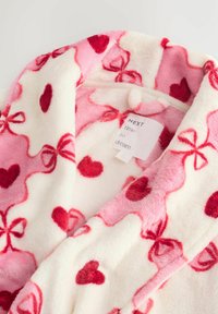 Fleece robe with a pink and white pattern featuring red hearts and bows. Soft texture with a cozy collar and hanging tag showing brand name.