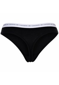 Svart bomullsbikini med ett vitt elastiskt midjeband som pryds av Lacoste-logotypen. Slät textur och låg midja för minimal täckning.