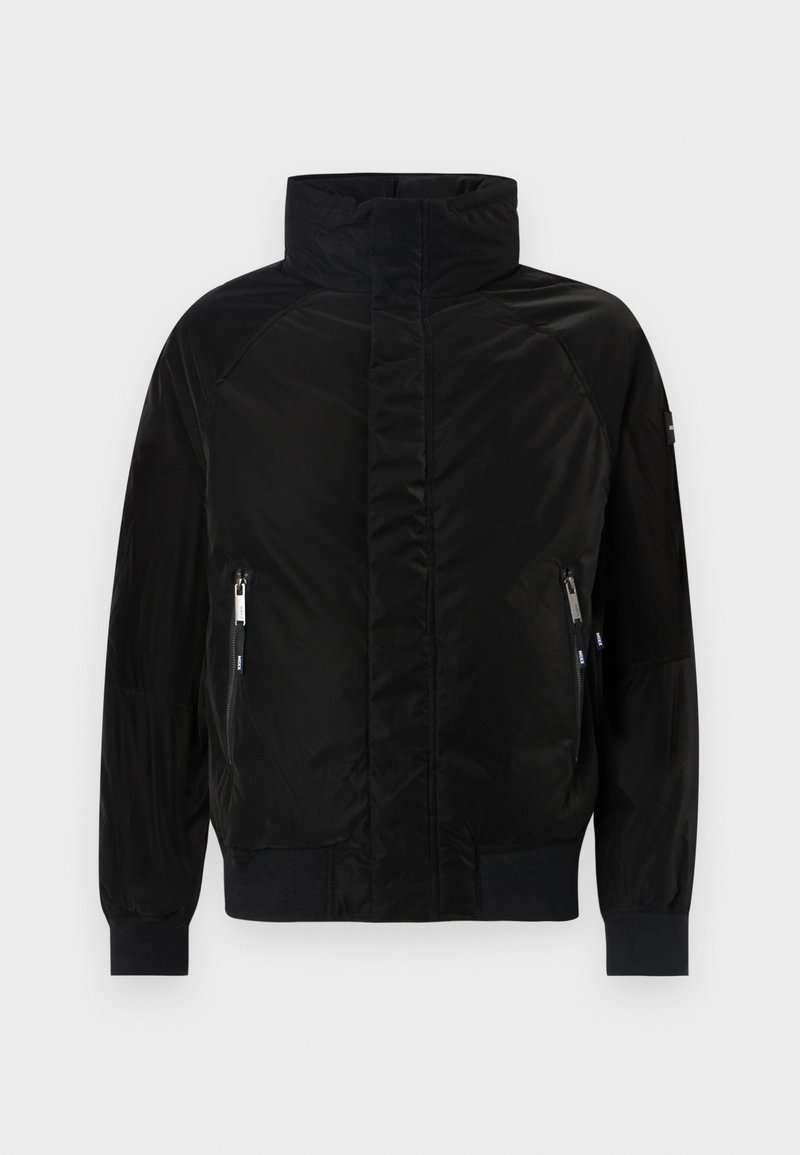 Chaqueta acolchada negra con un cuello alto, mangas largas y puños acanalados. Presenta dos bolsillos frontales con cremallera y un acabado suave similar al satén.