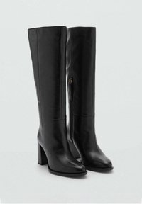 Bottes montantes noires en cuir avec bout carré, talon bloc et fermeture éclair latérale. Texture lisse et design structuré, idéal pour les tenues formelles.