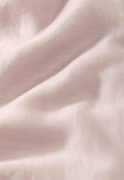 Απαλό, ανοιχτό ροζ ύφασμα με απαλά πτυχώσεις και λεία, ελαφρώς υφή επιφάνεια.