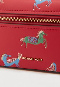 Portafoglio in pelle rossa con motivi giocosi di cavalli in blu e verde, con logo del marchio in oro e dettagli con cerniera.