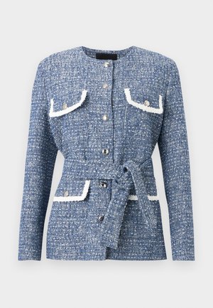 Chaqueta azul de tweed texturizado con botones plateados, bolsillos con solapa y ribete blanco, mangas largas y un cinturón a juego atado a la cintura.