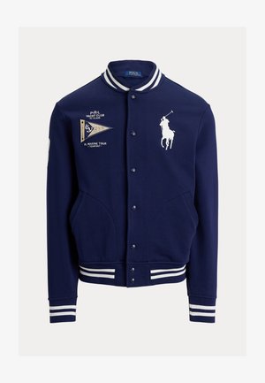Marineblå varsity jakke med hvidstribet krave og manchetter, forlommer, broderet polo-spiller logo og yachtklub tekst med et vimpelmærke.