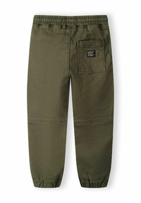 Olive green cotton cargo pants with elastic waistband, tapered ankles, and a back pocket featuring a black label. Smooth texture.