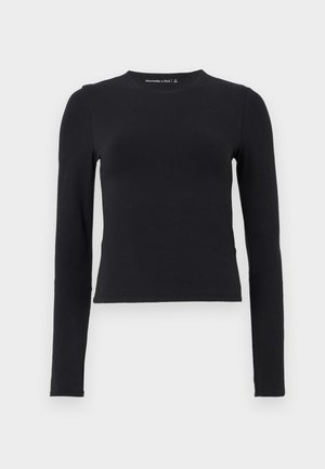 Black long-sleeve shirt made of soft cotton, featuring a crew neck and a fitted design with minimal stitching and no embellishments.