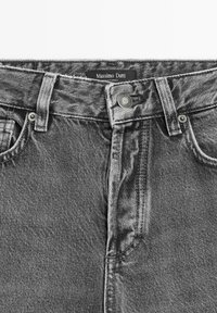 Grey denim jeans waist with button closure, belt loops, front pockets, and Massimo Dutti brand label inside the waistband.