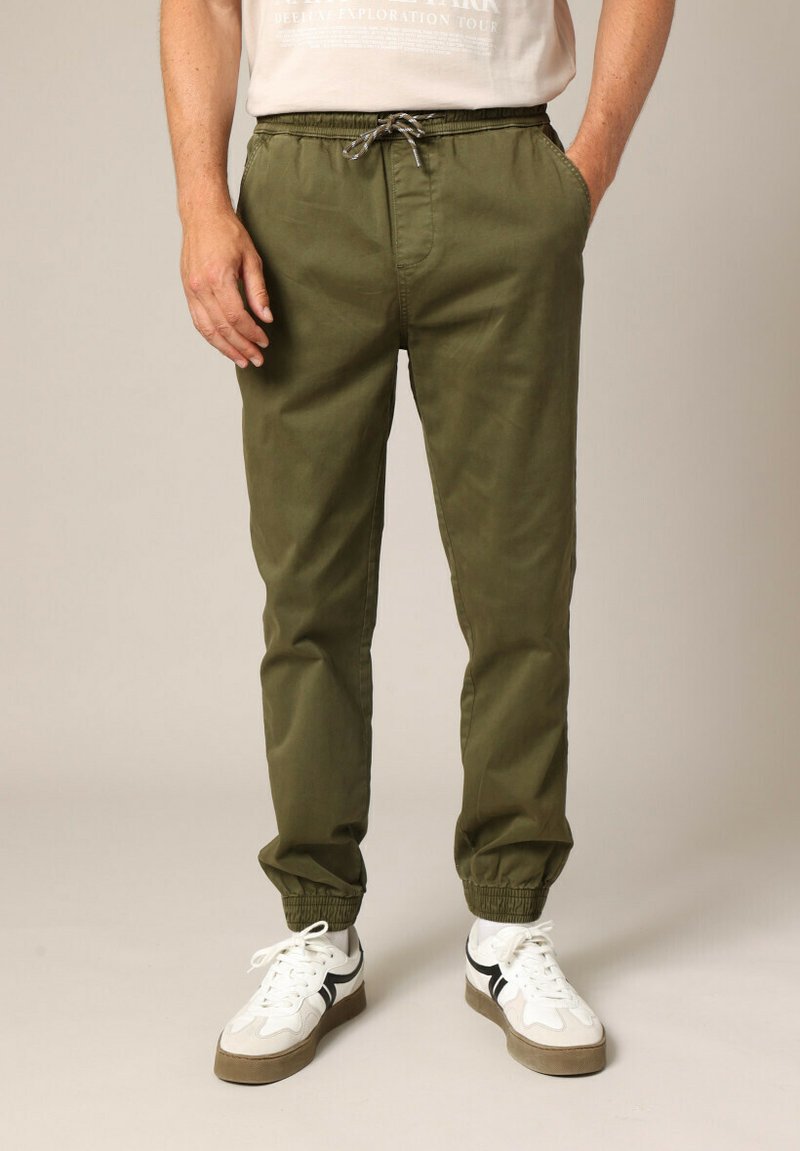 Pantalons de jogging légers de couleur vert olive, avec une taille élastique et un cordon de serrage réglable, dotés de poches latérales et de poignets élastiques aux chevilles.