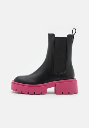 Sort læderankelstøvle med elastiske sidepaneler og kraftig, lys pink sål og hæl mod hvid baggrund.