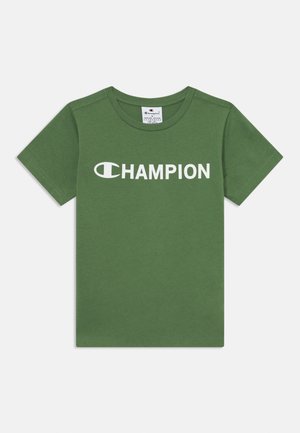 Vihreä puuvillainen t-paita, jossa on lyhyet hihat ja pyöreä kaula-aukko. Edessä on valkoinen "CHAMPION"-logo.