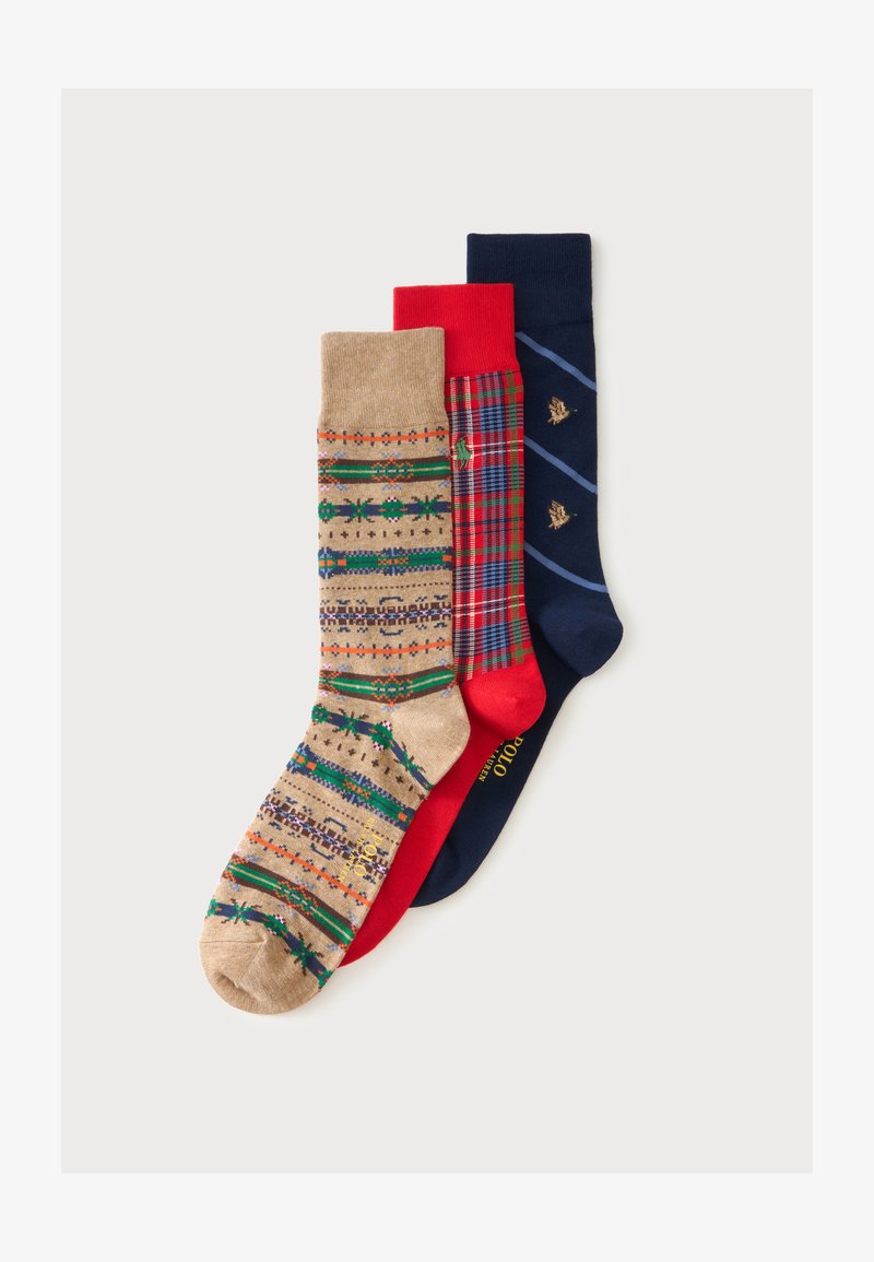 Trois chaussettes plates à motifs : beige avec des rayures géométriques, rouge avec un motif à carreaux, et bleu marine avec des rayures diagonales et petits motifs.