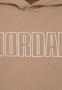 Felpa marrone con cappuccio caratterizzata da un motivo geometrico testurizzato e grandi lettere bianche che spellano "JORDAN" sulla parte anteriore.