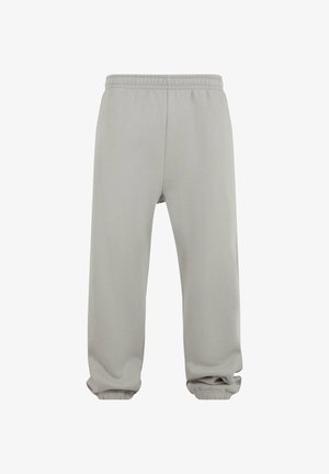 Pantaloni della tuta grigio chiaro realizzati in tessuto morbido, con vita elasticizzata, polsini affusolati e una vestibilità comoda. Nessuna tasca visibile.