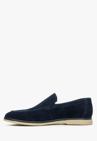 Granatowe zamszowe buty wsuwane z przeszywanymi detalami, okrągłym noskiem i kontrastującą jasnobeżową gumową podeszwą. Minimalistyczny design, bez sznurówek.