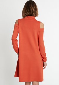 Orangenes langärmliges Kleid mit hohem Kragen, Cut-outs an den Schultern und lockerer Passform, aus glattem Stoff und mit leicht ausgestellt gesäumtem Saum.