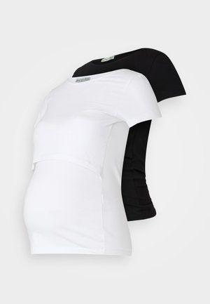 Schwarze und weiße Umstandst-Shirts mit kurzen Ärmeln aus weichem Baumwollmaterial, die ein schichtetes Design mit einem gerafften Abschnitt für einen wachsenden Bauch aufweisen.