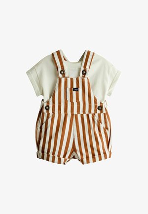 Kremowy t-shirt z krótkim rękawem zestawiony z brązowymi i białymi pionowymi paskami na krótkich ogrodniczkach z guzikami i przednią kieszenią.