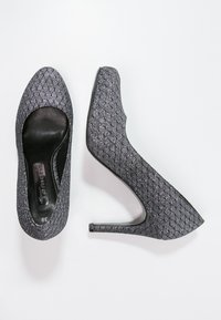 Chaussures à talons hauts noires avec une surface texturée et scintillante. Design à bout pointu et silhouette épurée. Talon aiguille de 10 cm.