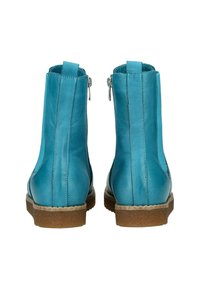 Bottines en cuir bleu avec une texture lisse, fermeture éclair et semelle en caoutchouc marron. Des coutures verticales sur les côtés ajoutent du détail.