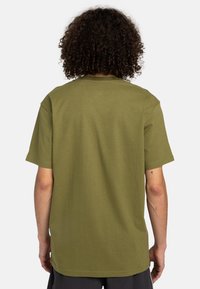 Oliven grøn bomulds t-shirt med afslappet pasform, korte ærmer og lige kant med et enkelt design. Ingen grafik eller detaljer.