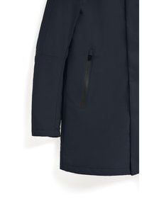 Marinblå vattentät jacka med en slät yta, långa ärmar och en sidoficka med dragkedja i svart.