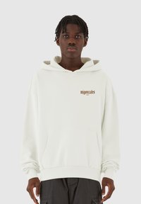 Weißer Hoodie mit Kängurutasche, Kordelzugkapuze und braunem Schriftzug "mjgonzales" auf der Brust. Verfügt über gerippte Bündchen und einen lässigen Schnitt.
