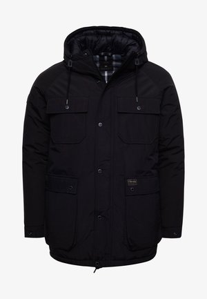 Musta toppatakki hupulla, edessä vetoketju ja painonapit, neljä läppätaskua sekä säädettävät hupun kiristysnyörit.