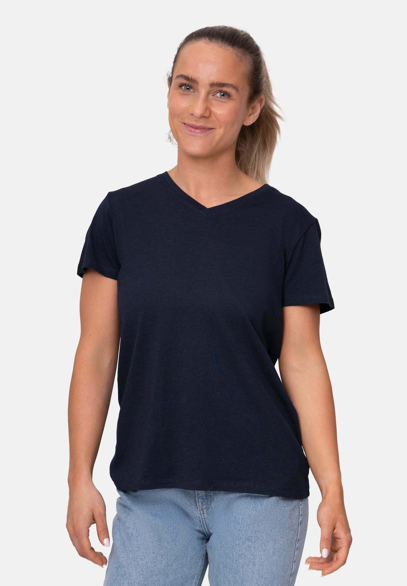T-shirt blu navy a V in morbido tessuto, con maniche corte e vestibilità rilassata, indossata con jeans azzurri.