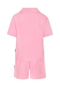 Set di pigiama corto rosa in tessuto morbido, composto da una maglietta con colletto e pantaloni corti, con un sottile motivo a logo ripetuto su tutto il tessuto.