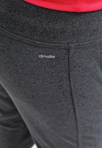 Grijze sweatpants van zachte stof, met een geribde tailleband en een klein "climalite" logo op de bovenbeen.