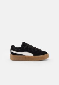 Czarne zamszowe sneakersy z białym paskiem po bokach, okrągłym noskiem, płaskimi sznurówkami i fakturowaną gumową podeszwą. Posiadają wyściełaną kołnierz.