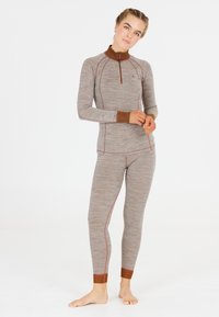 Långärmad thermotop och figurnära leggings i en melerad brun tyg med kontrasterande bruna krage och ärmslut, med röda sömdetaljer.