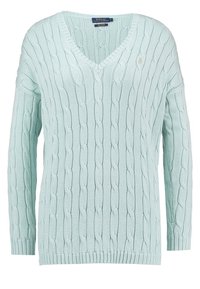 Ljus mintgrön kabelstickad tröja med djup V-hals, långa ärmar, ribbade muddar och nederkant, samt en liten logotyp på bröstet.